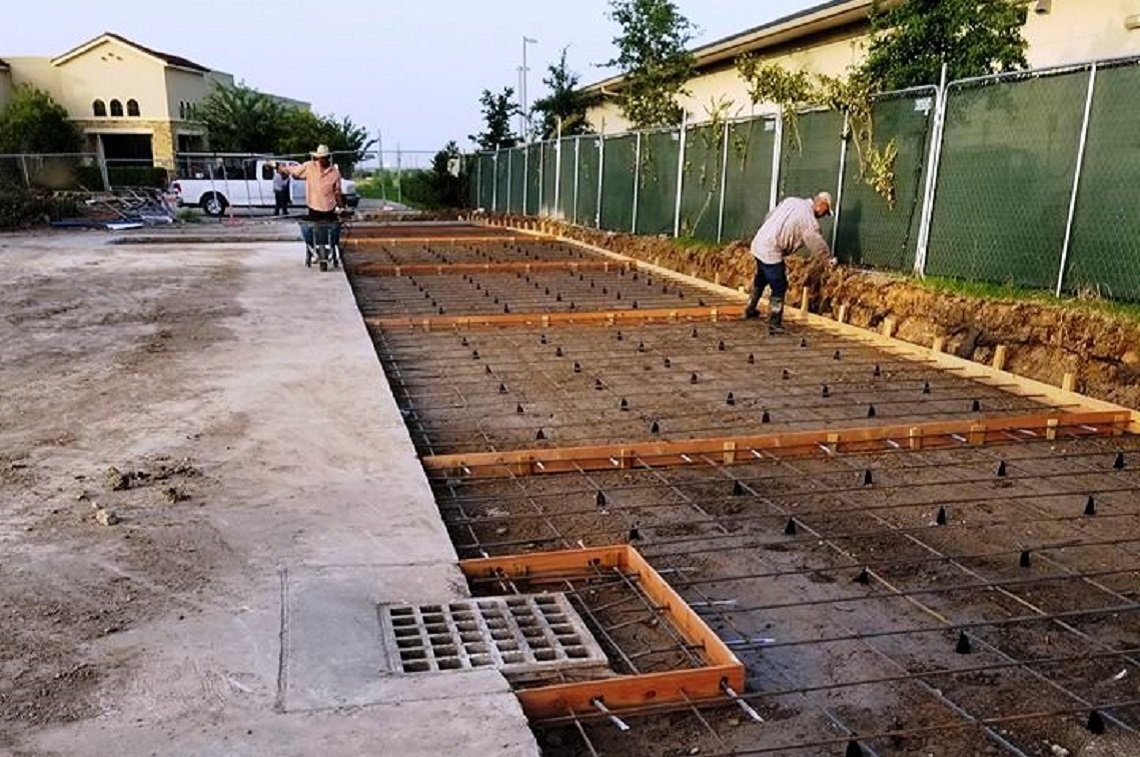 Jerson's Concrete crew setting rebar and expansion joint forms for a new parking lot pour in Houston